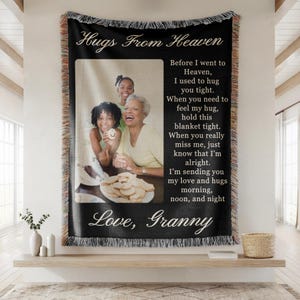 May include: Black woven throw blanket with a photo of three smiling people and the text "Hugs From Heaven" and "Love, Granny". The blanket has a fringed edge and a poem about love and remembrance.