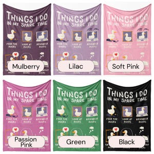 May include: Six different colored fleece blankets with the text "Things I do in my spare time" and a cartoon duck doing different activities. The blankets are in the colors mulberry, lilac, soft pink, passion pink, green, and black.
