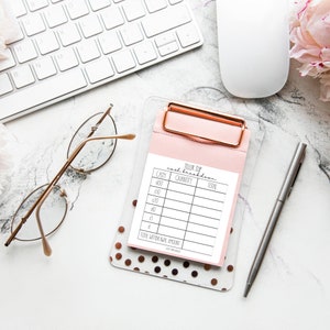 Può includere: Un foglio di riepilogo del contante stampabile bianco con uno sfondo rosa e una cartellina portadocumenti dorata. Il foglio ha colonne per l'importo in contanti, la quantità e il totale. Il foglio è etichettato "Teller Sup Cash Breakdown".