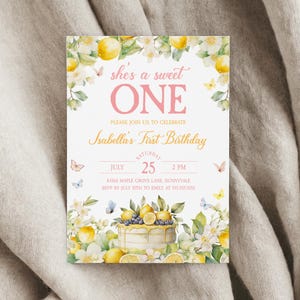 May include: A lemon-themed first birthday party invitation with a watercolor illustration of a lemon cake, lemons, and butterflies. The text reads "She's a sweet one" and "Isabella's First Birthday". The invitation includes the date, time, and location of the party.