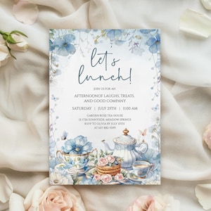 Könnte beinhalten: Eine Aquarell-Einladung mit dem Text "Let's Lunch!" zeigt blaue Blumenakzente, eine Teekanne, eine Teetasse und Gebäck. Die Einladung enthält Details für eine Afternoon-Tea-Party, einschließlich Datum, Uhrzeit und Ort.