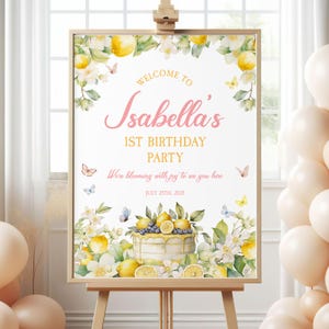 Könnte beinhalten: Ein Willkommenszeichen für eine 1. Geburtstagsparty mit einem Zitronen- und Blumenthema. Das Schild lautet "Willkommen bei Isabellas 1. Geburtstagsparty. Wir blühen vor Freude, dich hier zu sehen. 25. Juli 2035".