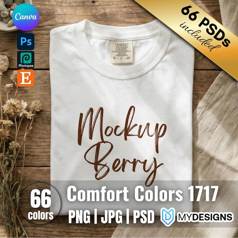 May include: A white short-sleeved t-shirt with a crew neckline and a Comfort Colors brand label at the inner collar. The front of the shirt features the brown text Mockup Berry in a script font. The garment is displayed flat on a wooden surface.