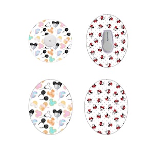 Könnte beinhalten: Vier verschiedene Designs für ein rundes medizinisches Gerät mit weißem Hintergrund und einem sich wiederholenden Muster aus Mickey Mouse und Minnie Mouse Figuren. Ein Design zeigt ein Muster aus Mickey Mouse Ohren, Ballons und Leckereien. Ein anderes Design zeigt ein Muster aus Minnie Mouse Köpfen mit roten Schleifen und weißen Punkten. Das dritte Design zeigt ein Muster aus Mickey Mouse Ohren, Ballons und Leckereien. Das vierte Design zeigt ein Muster aus Minnie Mouse Köpfen mit roten Schleifen und weißen Punkten.