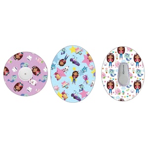 Può includere: Tre coperture adesive rotonde per dispositivi medici con un motivo a cartoni animati colorato che presenta una ragazza, un gatto, un pesce e una stella. Il motivo è su uno sfondo azzurro, rosa e bianco. Le coperture sono progettate per adattarsi a un dispositivo medico.