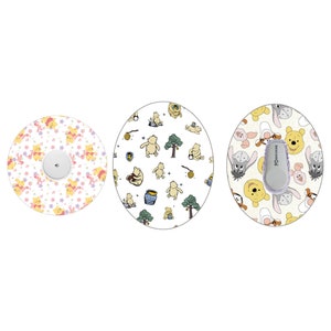 May include: Three round, white, adhesive stickers with different Winnie the Pooh designs. The first sticker features Winnie the Pooh and Piglet in pink, yellow, and white. The second sticker features Winnie the Pooh and honey pots in yellow, green, and brown. The third sticker features Winnie the Pooh, Piglet, and Tigger in yellow, brown, and gray.