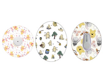 Peut inclure: Trois autocollants ronds, blancs et adhésifs avec différents motifs Winnie l'ourson. Le premier autocollant représente Winnie l'ourson et Porcinet en rose, jaune et blanc. Le deuxième autocollant représente Winnie l'ourson et des pots de miel en jaune, vert et marron. Le troisième autocollant représente Winnie l'ourson, Porcinet et Tigrou en jaune, marron et gris.