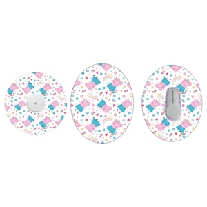 Puede incluir: Tres parches adhesivos redondos con fondo blanco y un patrón repetido de cerdos rosas con vestidos azules y sosteniendo flores rosas. El parche central tiene un pequeño dispositivo rectangular gris con el texto "Dexcom G6" impreso en él.