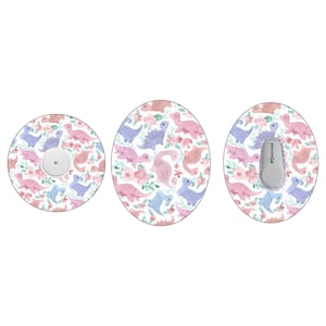 Puede incluir: Tres pegatinas redondas con fondo blanco y un patrón de dinosaurios rosas, morados y azules con flores rosas. Las pegatinas son para un dispositivo médico.