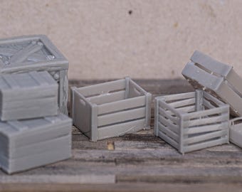 May include: Five gray wooden crates of various sizes. The crates are stacked and arranged on a wooden surface.