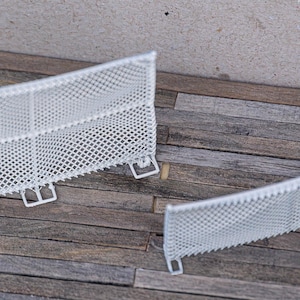 Könnte beinhalten: Zwei weiße Plastik-Fußballtore mit Netz auf einer Holzoberfläche.