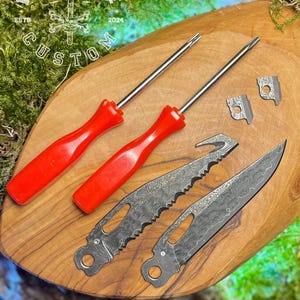 May include: Two red handled screwdrivers and two small knives with a patterned blade. The knives have a black handle and a serrated edge. The screwdrivers and knives are on a wooden surface. The text "FORGE & BONE ESTB 2024 CUSTOM" is visible in the top left corner of the image.