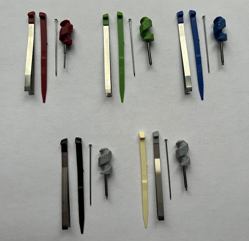 May include: Set of ten tools for watch repair, including tweezers, screwdrivers, and a spring bar tool. The tools are arranged in pairs, with each pair featuring a different color.