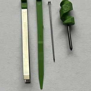 May include: Three tools for crafting: a green plastic needle tool, a green plastic tool with a pointed end, and a silver metal tool with a white stripe.