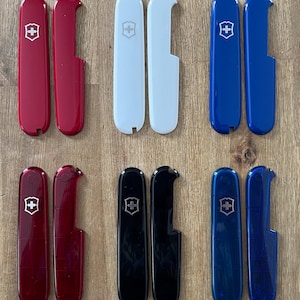 May include: Six pairs of Swiss Army Knife scales in various colors, including red, white, black, and blue. Each pair features the iconic Swiss Army Knife logo.