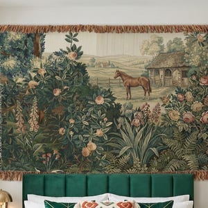 May include: A rectangular woven wall tapestry featuring a pastoral landscape with a brown horse, a stone building, and lush garden foliage including roses and ferns. The tapestry has fringed edges and measures 80 inches by 60 inches.