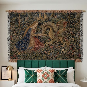 May include: A woven wall tapestry measuring 203 cm by 152 cm, featuring a detailed scene of a person in medieval-style clothing interacting with a dragon in a floral meadow, with a castle in the background and fringed edges on the sides.