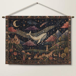 Puede incluir: Un tapiz de pared rectangular tejido que muestra un cielo nocturno oscuro con una luna creciente, estrellas, un cometa y una gran ballena nadando. El paisaje incluye un castillo, montañas, un faro, árboles, flores y animales pequeños.