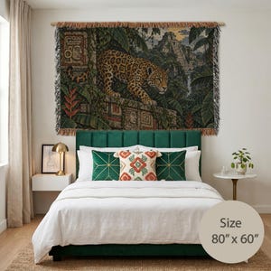 May include: A rectangular woven wall tapestry featuring a detailed jungle scene with a jaguar prowling along stone ruins, ancient carvings, and a pyramid in the background. The tapestry has a fringed edge and measures 203.2 cm by 152.4 cm.