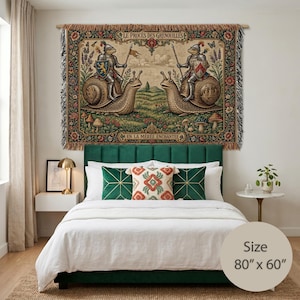 May include: A rectangular woven wall tapestry measuring 80 inches by 60 inches, featuring two frogs in medieval armor riding snails. The scene includes floral borders, mushrooms, and the text LE PROCÈS DES GRENOUILLES and EN LA MÉRÉE ENCHANTÉE.