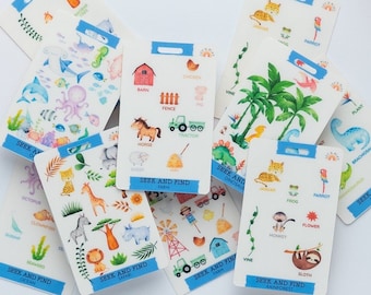 Op de afbeelding: Een set kleurrijke houten blokken en een stapel kaarten met illustraties van dieren, planten en voorwerpen. De kaarten hebben de tekst "Seek and Find" erop.