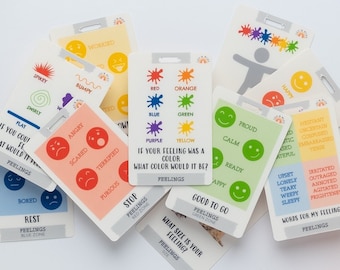 Op de afbeelding: Een set kleurrijke kaarten met verschillende emoties en activiteiten erop gedrukt. De kaarten zijn ontworpen om kinderen te helpen hun gevoelens te identificeren en uit te drukken. De kaarten bevatten een verscheidenheid aan kleuren, waaronder rood, oranje, geel, groen, blauw, paars en roze.