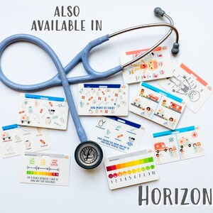 May include: A set of colourful medical themed flash cards with illustrations and text. The cards include a human body diagram, a skeleton, a pain scale, and a card that asks "How many can you lace?" The cards are laid out on a white surface with a blue stethoscope.