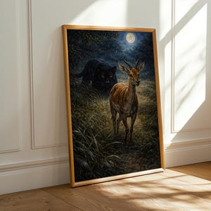 May include: A framed art print depicts a deer in a grassy field under a full moon, with a black panther lurking in the background. The artwork is set in a wooden frame and leans against a white wall.