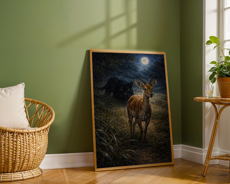 May include: A framed art print depicts a deer in a forest under a full moon, with a black panther in the background. The artwork has a natural color palette and is set in a room with a green wall and a wicker chair.