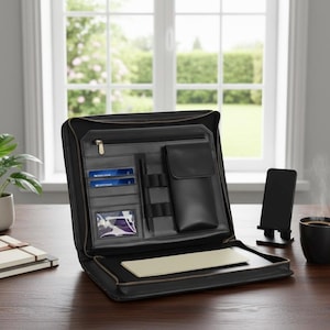 May include: A black leather portfolio case opened to reveal an interior organizer with a zippered pocket, multiple card slots, a clear ID window, two pen loops, and a vertical pouch. A cream-colored notepad is tucked into the bottom sleeve.