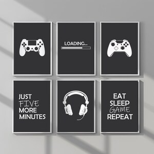 May include: Six black and white framed prints with gamer-themed designs. The prints feature a video game controller, a loading bar, headphones, and text that says "Just Five More Minutes" and "Eat Sleep Game Repeat".