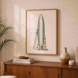 May include: A framed wall art print featuring a large, vertical, teal and white surfboard being painted by four small figures on ladders. The illustration is set against a plain, light-colored background, showcasing detailed artistic work.