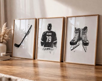 May include: Three framed art prints featuring hockey-themed illustrations. One print shows a hockey stick, another a hockey jersey with the name "Oliver" and the number "79", and the third displays a pair of ice skates. The prints are in black and white.