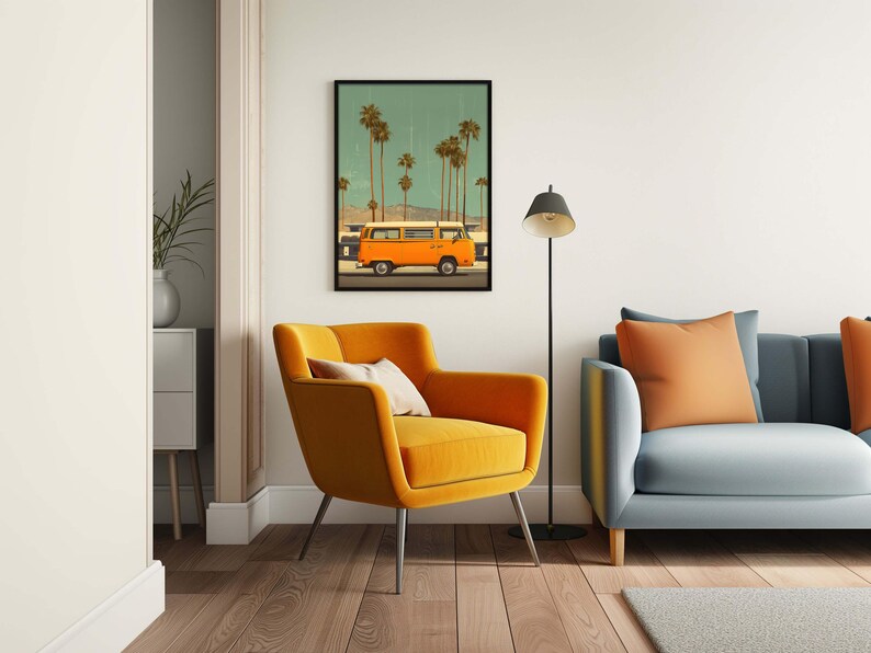 May include: A framed art print depicts an orange van driving past palm trees under a teal sky. The artwork hangs above a mustard yellow armchair with a cream-colored pillow. A gray sofa with orange pillows and a black floor lamp complete the room.