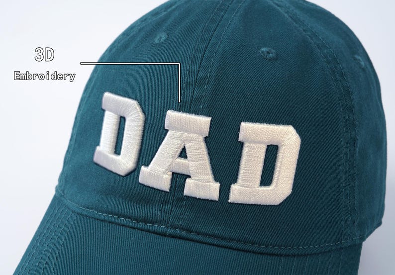 May include: A teal blue baseball cap with white 3D embroidery that reads "DAD".