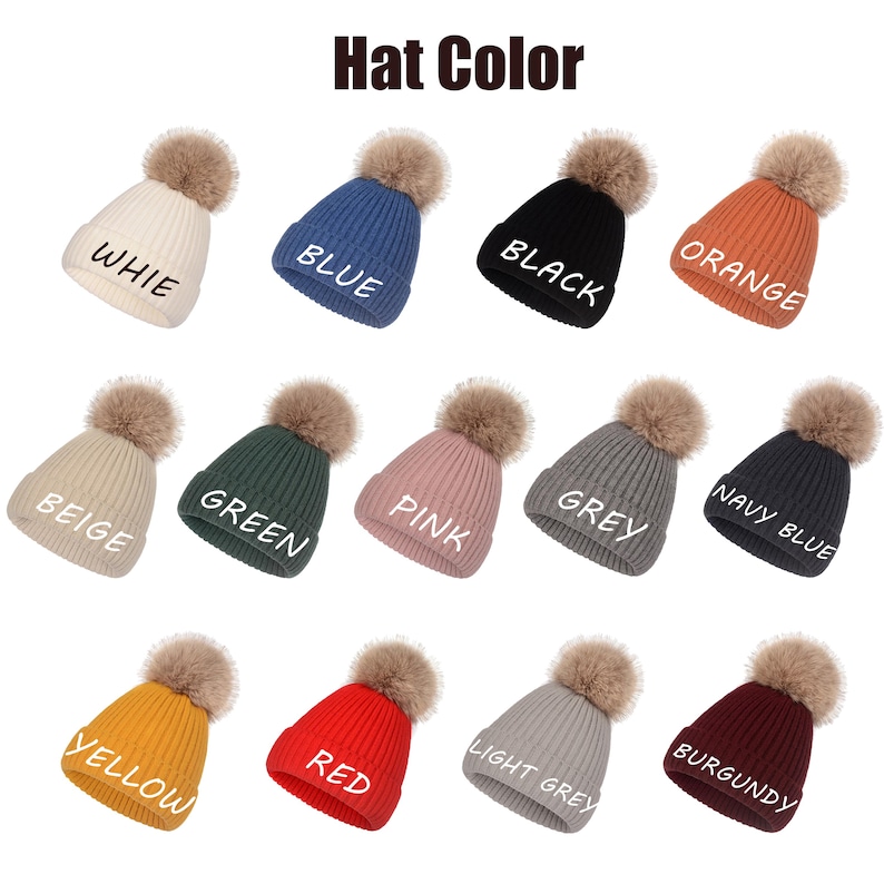 May include: A collection of thirteen ribbed knit beanies with faux fur pom-poms, displayed in various colors including white, blue, black, orange, beige, green, pink, grey, navy blue, yellow, red, light grey, and burgundy, each labeled with its color.