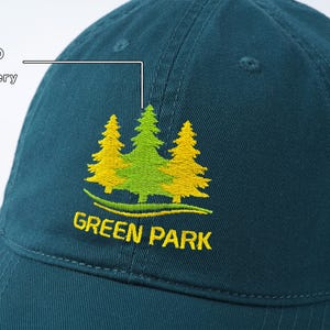 May include: A dark green baseball cap with an embroidered logo of three green trees with yellow accents. The logo reads "GREEN PARK".