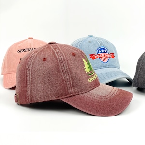 May include: Several baseball caps in shades of pink, burgundy, and light blue. The burgundy cap has a green tree design and the word "GREEN". The light blue cap features a "FREEDOM" emblem.