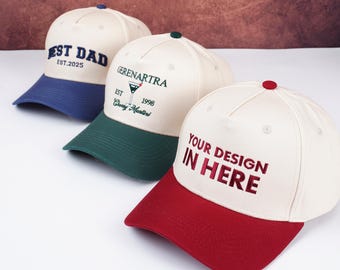 May include: Three baseball caps with different designs. One cap has "BEST DAD EST.2025" embroidered on the front, another has "GERENARTRA EST 1998 Crazy Martini", and the third says "YOUR DESIGN IN HERE". Each cap has a different colored brim.