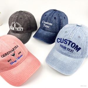 May include: Four baseball caps in different colours: black, navy blue, light blue, and pink. Each cap has embroidered text, including "Custom Text," "Always Fresh," and "Gerenartra." The caps have a classic, casual style.