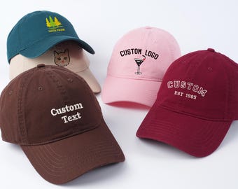 May include: Four different baseball caps with various embroidered designs. The caps are brown, pink, red, and green. The designs include a cat, a cocktail glass, the words "Custom Logo", and the words "Custom Text".