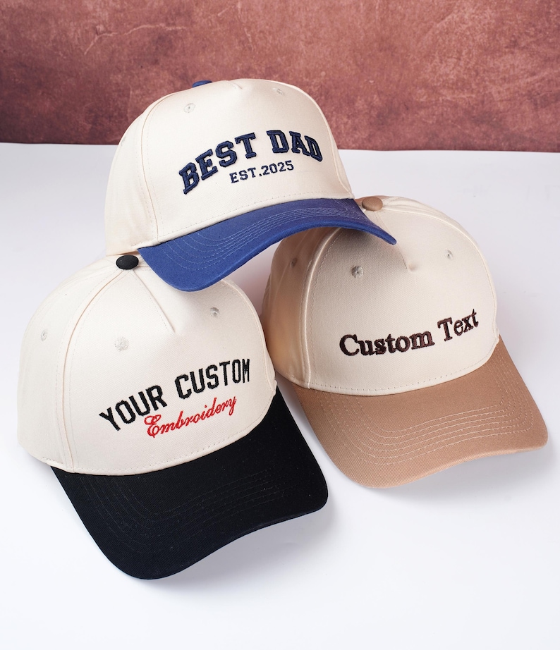 May include: Three baseball caps with embroidered text. One cap has "BEST DAD EST.2025" in navy blue, another says "YOUR CUSTOM Embroidery" in black and red, and the third says "Custom Text" in brown.