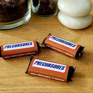 May include: Three brown chocolate bars with blue and white labels that read "Precursores" and "Simple Completamente In Ministerio".