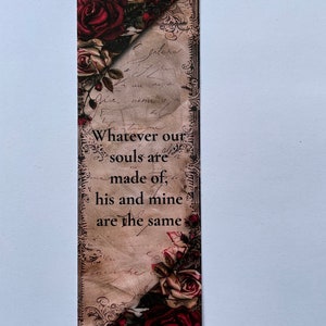 May include: A rectangular bookmark featuring a vintage-style background with cursive script and dark red roses at the top and bottom corners. The text reads: Whatever our souls are made of, his and mine are the same, printed in black.