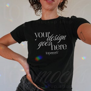 Puede incluir: Una camiseta negra de cuello alto con el texto "your design goes here" y "topmocks" impreso en la parte delantera.