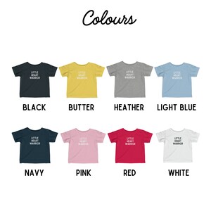 May include: A mockup of a t-shirt design in ten different colors. The design features the text "Little Heart Warrior" in white on a colored t-shirt. The colors are black, butter, heather, light blue, navy, pink, red, and white.