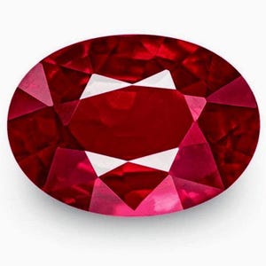 Könnte beinhalten: Ein oval geschliffener Edelstein in einer tiefen, gesättigten roten Farbe. Der Stein weist eine facettierte Oberfläche mit einer symmetrischen Anordnung von dreieckigen und rautenförmigen Facetten auf, die scharfe Lichtreflexe erzeugen.