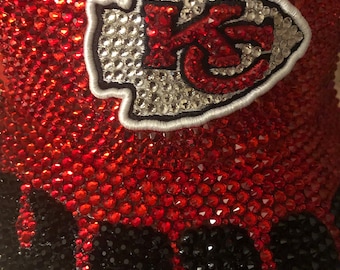 May include: A red and black rhinestone-covered item with a white and silver embroidered "K" logo.