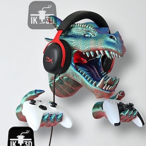 Op de afbeelding: Een iriserende draakvormige gaming headset- en controllerhouder in blauw, groen en rood. De bek van de draak houdt een headset vast en zijn handen omarmen twee gamecontrollers. De houder heeft de tekst "IK 3D".