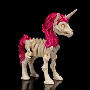 May include: A white skeleton unicorn figurine with a pink mane and tail. The unicorn is standing on a black surface.